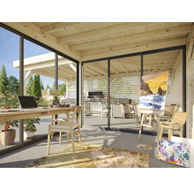 Pièce lumineuse avec plafond en bois, bureau, chaise, chevalet et vue sur le jardin avec espace barbecue