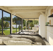 Pièce lumineuse avec plafond à poutres en bois, lit et vue sur le jardin à travers les fenêtres