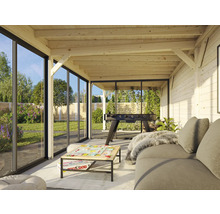 Véranda lumineuse avec construction en bois, portes coulissantes en verre, canapé et baby-foot