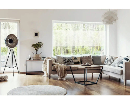 Wohnzimmer mit Sofa, Kissen, Couchtisch, Stehlampe und Fenster