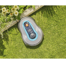 Robot tondeuse Gardena sur une pelouse près d''un parterre de fleurs