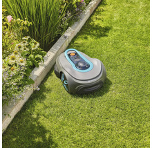Robot tondeuse Gardena sur une pelouse à côté d''un parterre de fleurs