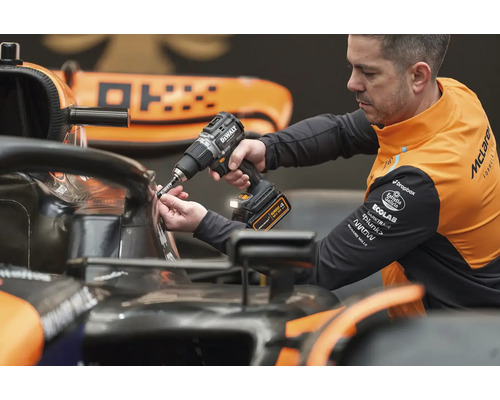 Une personne utilise un tournevis sans fil DeWalt sur une voiture de course.