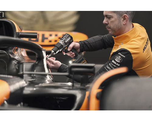 Un mécanicien utilise une visseuse sans fil DeWalt sur une voiture de course.