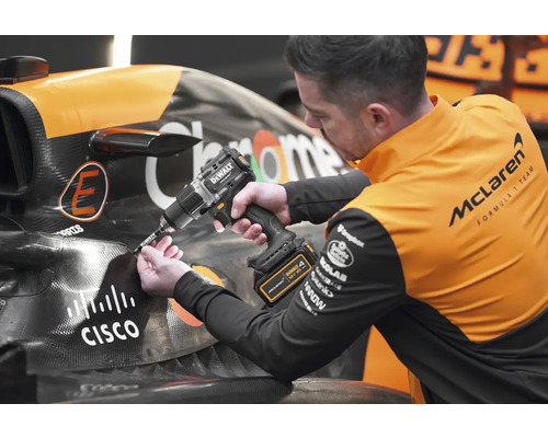Un mécanicien utilise une perceuse-visseuse sans fil DeWalt sur une voiture de course.