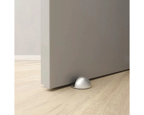 Butoir de porte en métal sur le sol devant une porte