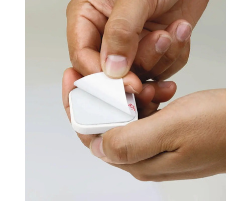 Des mains retirent le film protecteur d''un tampon adhésif