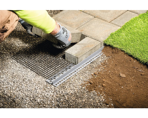 Travaux de pavage avec bordure de gazon, pavés et grille