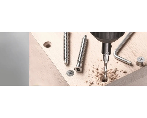Perceuse perçant un trou à côté de vis sur une planche en bois