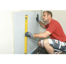 Handwerker richtet Trockenbauwand mit Wasserwaage aus