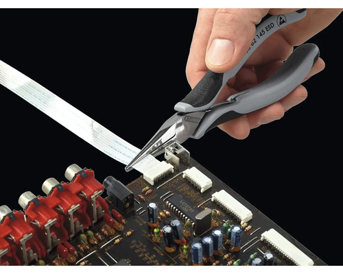 Eine Hand verwendet eine elektronische Spitzzange auf einer Platine.