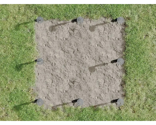 Surface carrée dans l''herbe avec neuf fondations vissées montées.