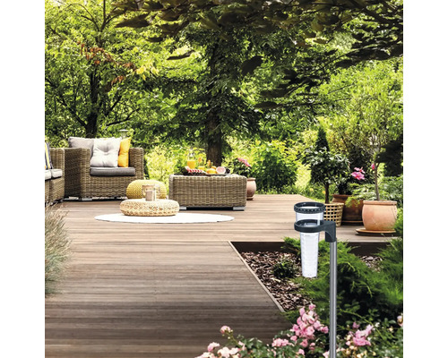 Scène de jardin avec terrasse, mobilier de jardin et pluviomètre pour mesurer les précipitations