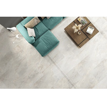 Heller Wohnraum mit Sofa, Tisch und Bodenfliesen in Marmoroptik