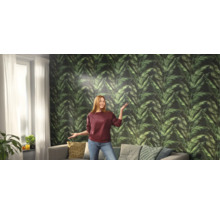 Salon avec papier peint à motifs de feuilles et une femme