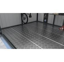 Plancher métallique structuré dans un espace de stockage avec vélo, établi et panneau d''outils