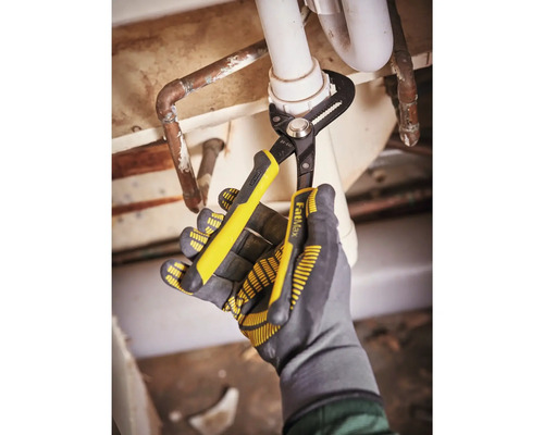 Eine Person benutzt eine Rohrzange an einem Abflussrohr, wobei sie Handschuhe trägt.