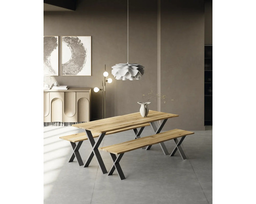 Salle à manger lumineuse avec table et deux bancs en bois avec pieds métalliques en forme de X, surmontée d''une suspension moderne.