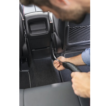 Une personne nettoie l''intérieur d''une voiture avec un aspirateur.
