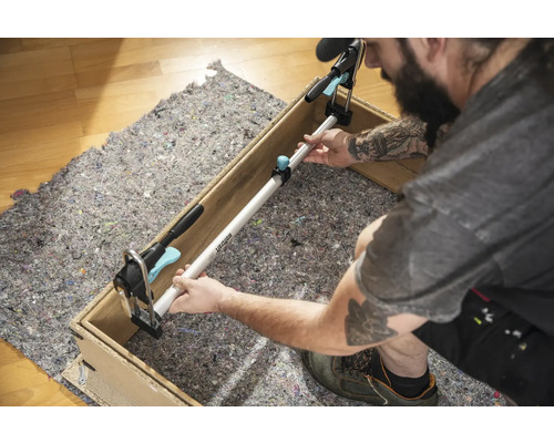 Handwerker befestigt eine Spannstange zwischen zwei Seiten eines Holzrahmens