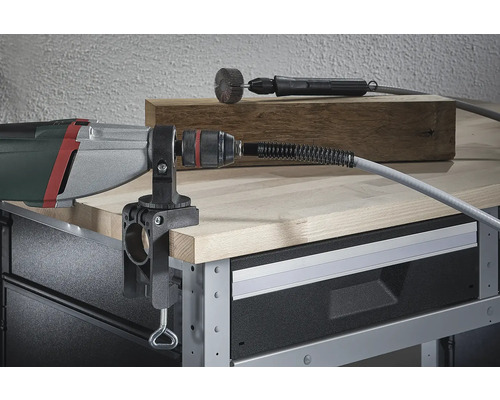 Outil électrique avec arbre flexible et serre-joint sur un établi