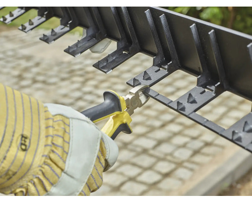 Aménagement de jardin avec bordure de pelouse en plastique et une pince.