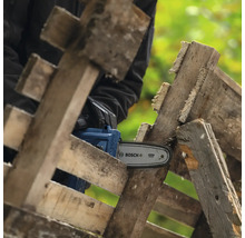 Akku-Kettensäge beim Sägen von Holzpaletten