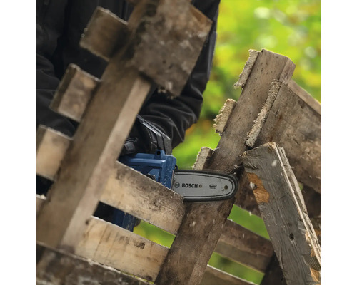 Akku-Kettensäge beim Sägen von Holzpaletten