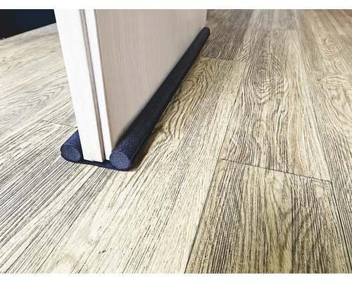 Türdichtung am unteren Ende einer Tür auf Holzboden
