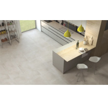 Cuisine claire avec carrelage au sol, kitchenette et îlot de cuisine avec des sièges.