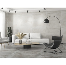 Salon lumineux avec canapé, fauteuil, lampadaire arc et carrelage mural et de sol grand format