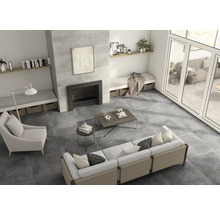 Salon lumineux avec carrelage, canapé, fauteuil et cheminée