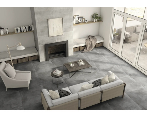 Salon lumineux avec carrelage, canapé, fauteuil et cheminée