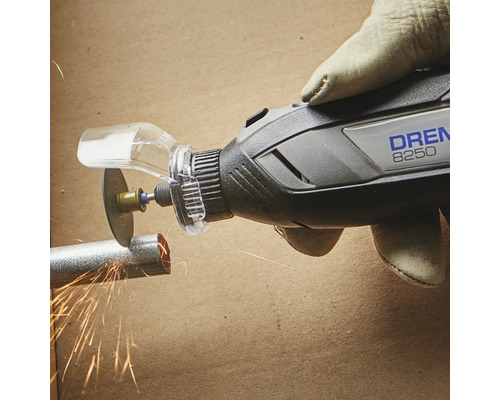 Outil multifonction Dremel 8250 coupant un tube métallique avec protection et projections d''étincelles