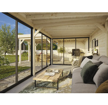 Salon lumineux avec plafond en bois, façade en verre et vue sur le jardin avec barbecue