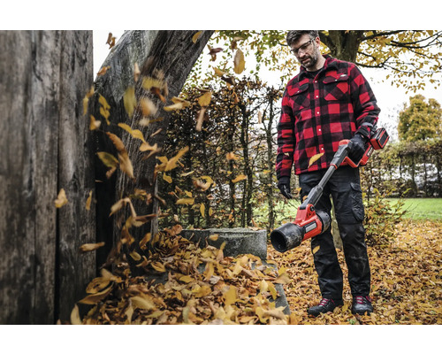 Mann mit Akku-Laubbläser im Garten beim Laubblasen