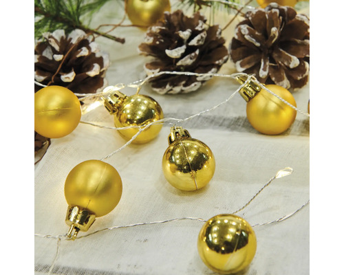 Dekorative Lichterkette mit goldenen Kugeln und Tannenzapfen
