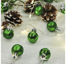 Grüne Christbaumkugeln mit Tannenzapfen und Lichterkette