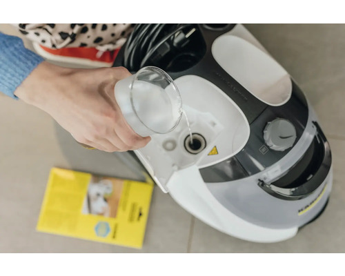 Une personne verse de l''eau dans un nettoyeur vapeur Kärcher