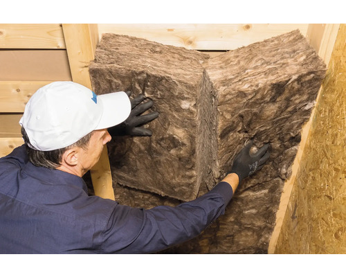 Une personne installant de la laine minérale pour l''isolation thermique.
