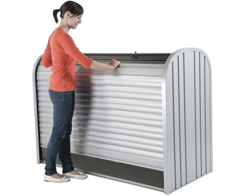 Femme ouvre un volet roulant de cabanon de jardin