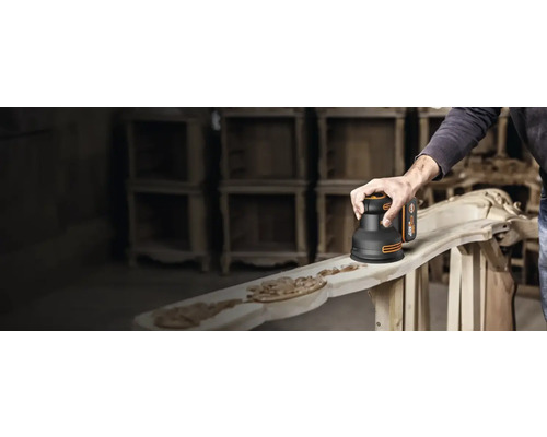 Akkuschleifer in Gebrauch zum Schleifen eines Holzstücks