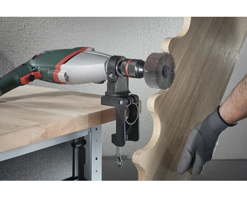 Outil électrique avec brosse abrasive et pièce en bois sur un établi