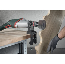 Elektrowerkzeug mit Schleifscheibe bearbeitet Holz mit Halterung am Tisch befestigt