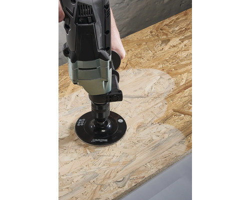 Une ponceuse travaille une plaque de bois.