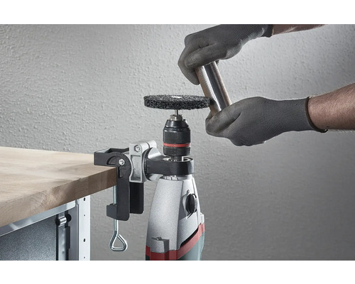 Eine Bohrmaschine mit Schleifscheibe und Werkstück auf einer Werkbank.