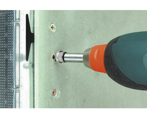 Vue détaillée d''un tournevis vissant une vis dans une plaque de plâtre, fixée sur une structure métallique.