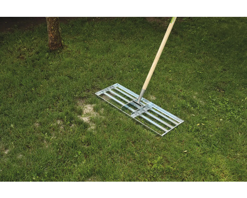 Râteau à gazon avec manche en bois sur l''herbe