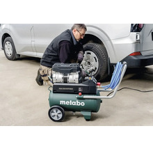 Un homme gonfle un pneu de voiture avec un compresseur Metabo.