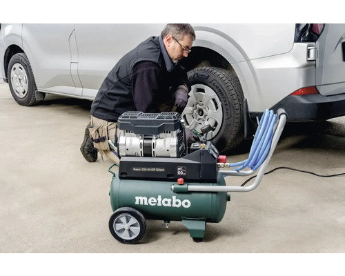 Un homme gonfle un pneu de voiture avec un compresseur Metabo.